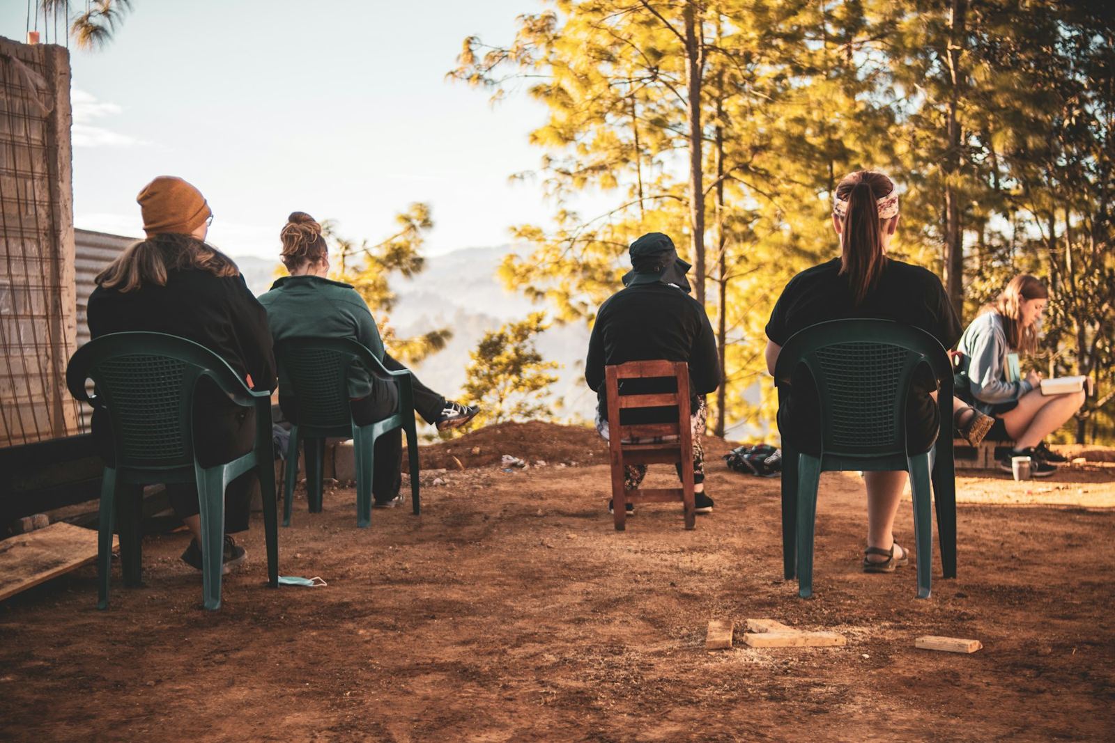 A small group of people sitting together on chairs outdoors